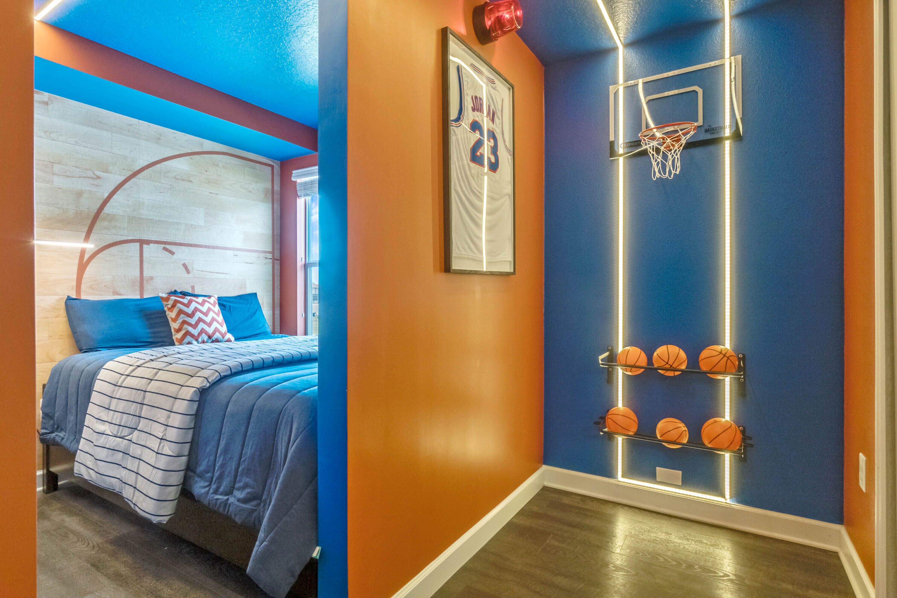 A bedroom with a bed, a basketball hoop, and a wall with basketballs.