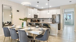 A modern kitchen with white cabinets, stainless steel appliances, and a central island.