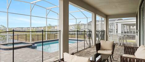 Relax by the pool in a serene outdoor space with a glass-enclosed view, wicker seating, and a flat roof.