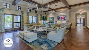 A spacious living room with a high ceiling, large windows, and a modern chandelier. - Last Minute Disney! Private Pool, Hot Tub & Themed Bedrooms. Book Now! #66161 (Orlando)