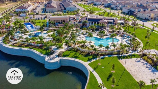A residential area with a large swimming pool surrounded by palm trees and houses. - Last Minute Disney! Private Pool, Hot Tub & Themed Bedrooms. Book Now! #66161 (Orlando)