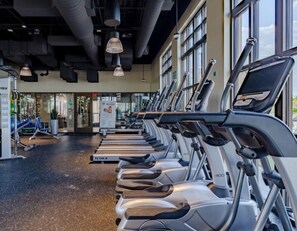A gym with treadmills, exercise machines, and large windows. - Last Minute Disney! Private Pool, Hot Tub & Themed Bedrooms. Book Now! #66161 (Orlando)