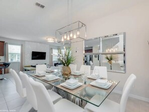Enjoy meals with family and friends at this spacious dining area, featuring a glass-top table and comfortable seating for six.