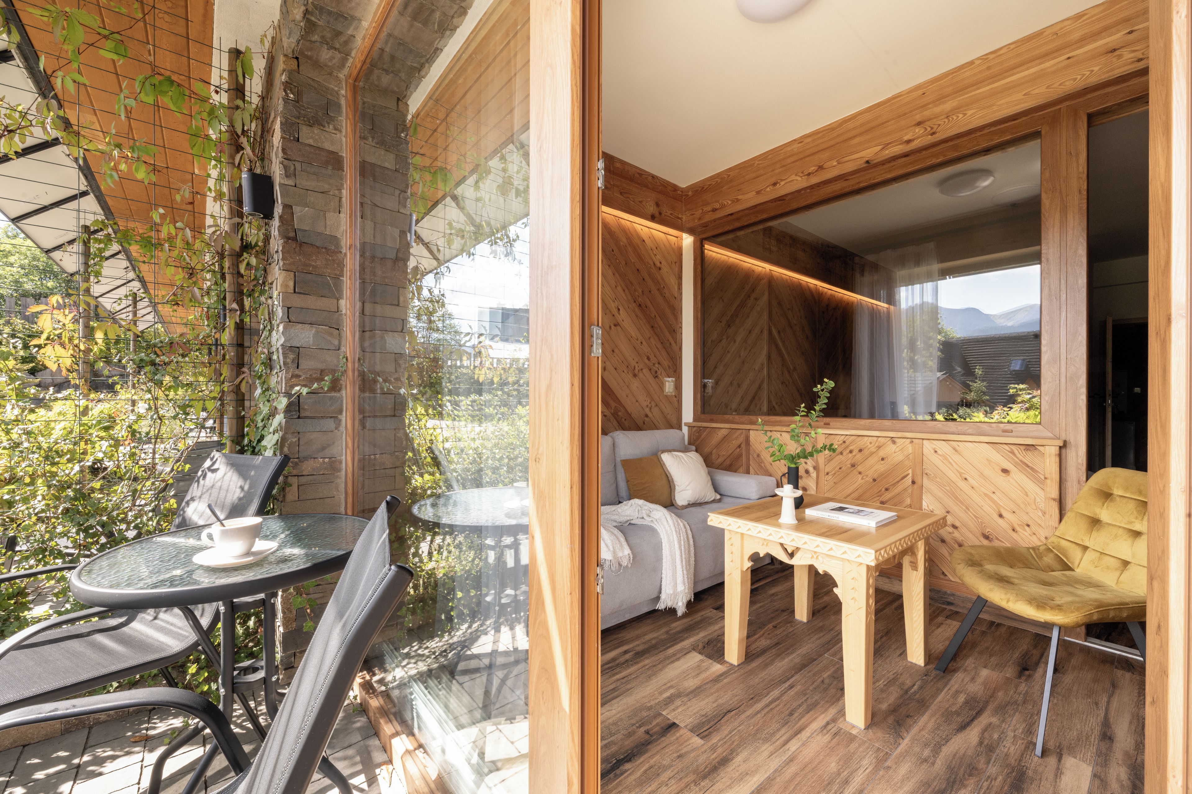 Un interior moderno con piso de madera, un sofá, una mesa y una silla.