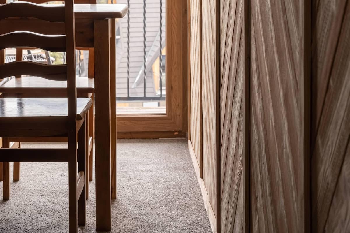 Un balcon en bois offrant une vue sur des montagnes enneigées.