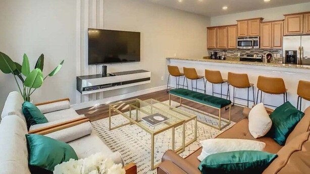 Uma sala de estar moderna com um sofá, mesa de centro e televisão de tela plana.