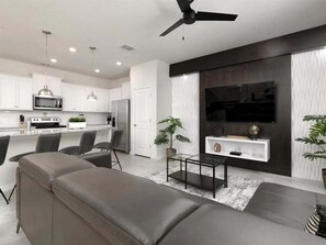 Relax in this stylish living space with a contemporary kitchen, flat-screen TV, and comfortable seating area.