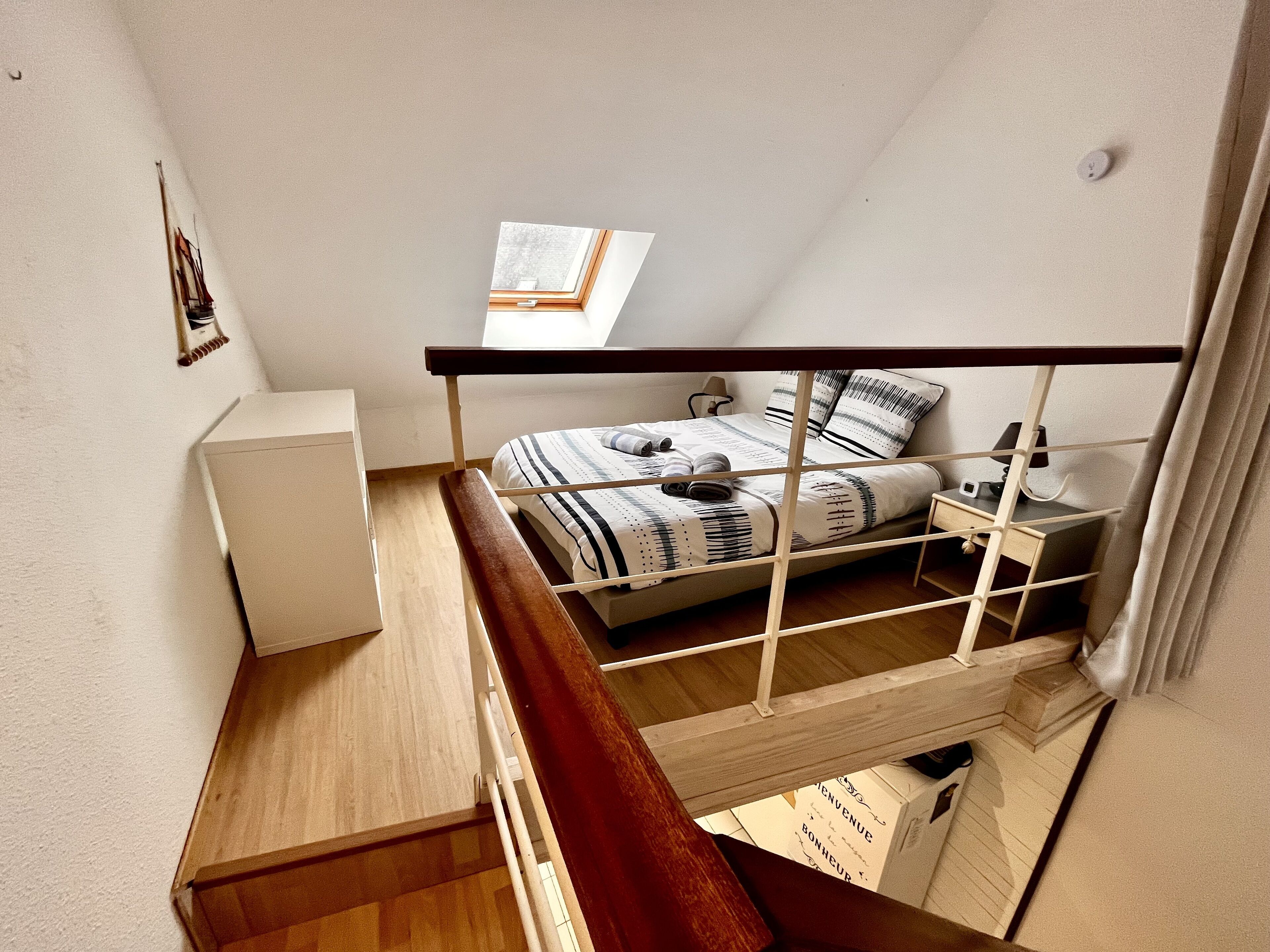 Habitación tipo dormitorio con una cama literera, un escritorio y un pequeño armario.