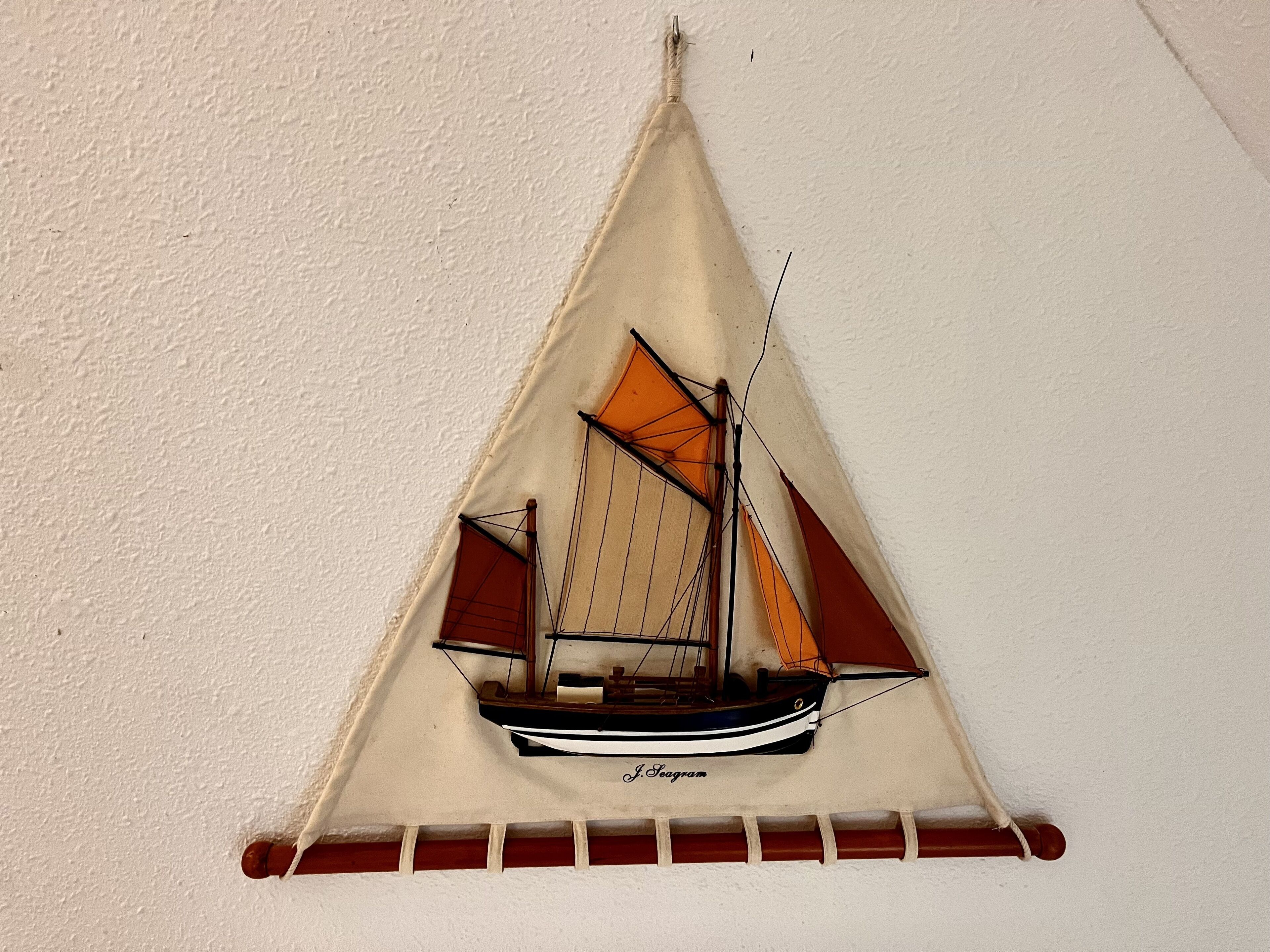 Ein an der Wand befestigtes Modell eines Segelbootes mit dem Namen 'J. Seagram'.