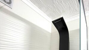 A modern shower with a black control panel and a wooden accent wall. - Nesi apartment  (Pristina)