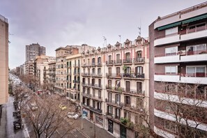 Une rangée d’immeubles résidentiels à plusieurs étages, dotés de balcons, une rue au premier plan et un immeuble plus haut en arrière-plan.