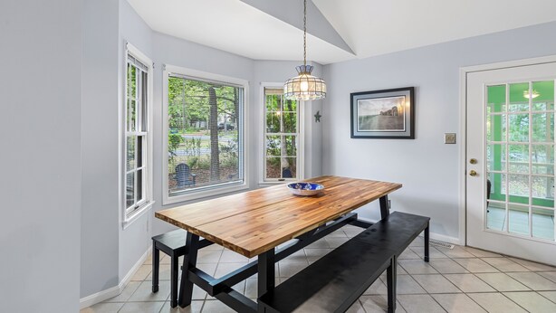 Un espace repas avec une table en bois, un banc et une suspension.