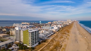 A coastal cityscape with a long beach, modern buildings, and a water tower. - Summer Beach 603 by Seaside Vacations & Sales (Ocean City)