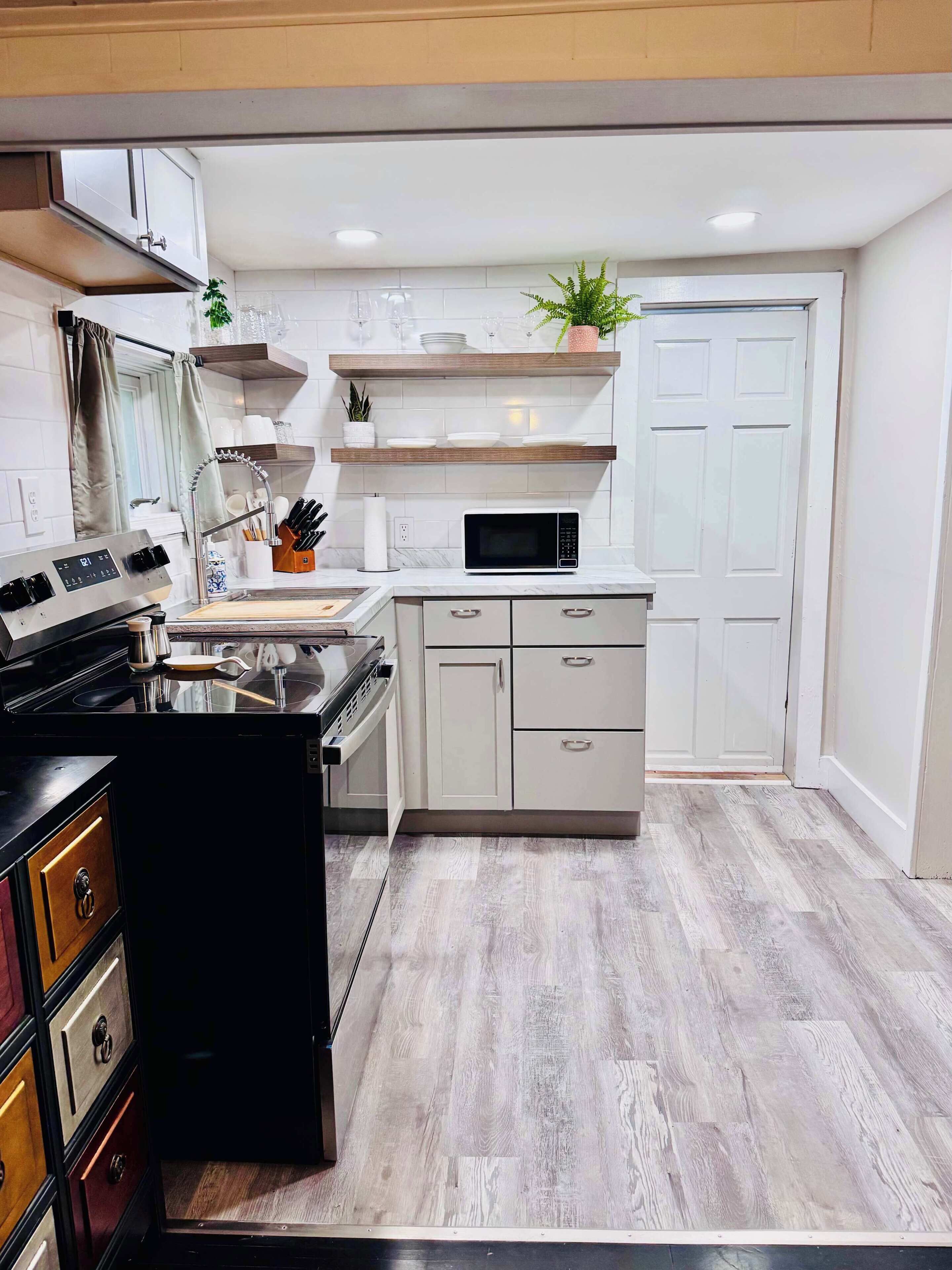 A modern kitchen with a stove, microwave, and cabinets.