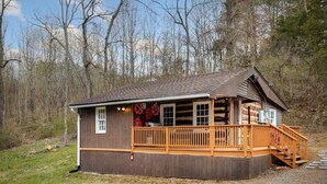 A wooden cabin with a porch and a staircase leading to a deck. - Creekside Cabin w Hot Tub, Fire Pit, Deck & Grill! (Mount Jackson)