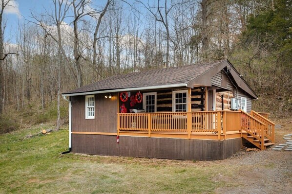 A wooden cabin with a porch and a staircase leading to a deck. - Creekside Cabin w Hot Tub, Fire Pit, Deck & Grill! (Mount Jackson)