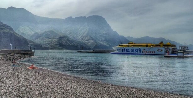 A ferry named 'FRED. OLSEN Express' docked at a harbor with mountains in the background. - Apartamento Estudio Mirador de los Poetas (Puerto de las Nieves)