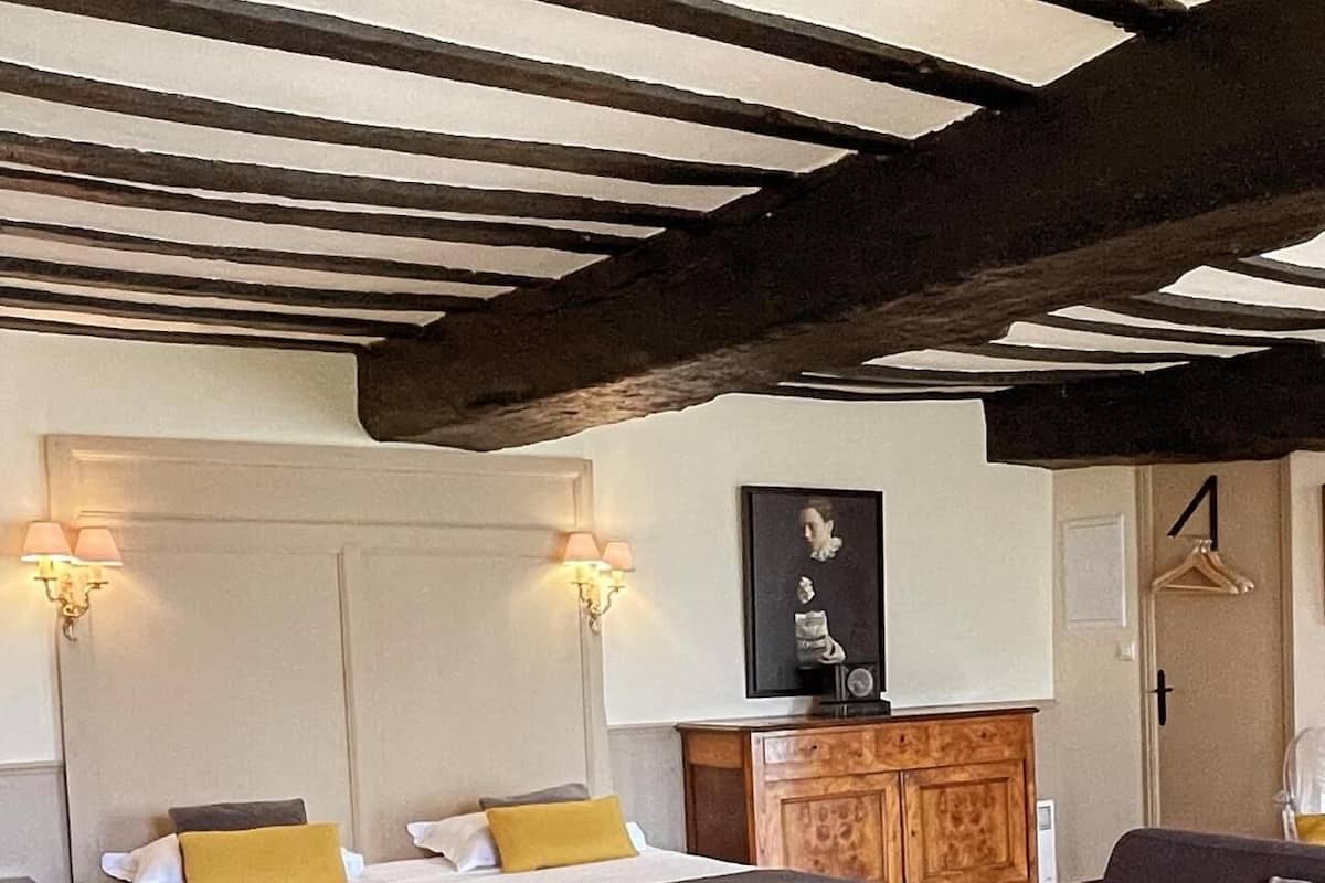 Een kamer met een bed, twee nachtkastjes, een bank, een klein rond tafeltje en een kast.