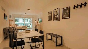 Una sala de estar moderna con comedor, que incluye un sofá, una mesa de comedor con sillas y un banco.