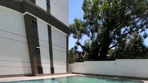 A rectangular pool with clear water, surrounded by a tiled deck. - Maya 3-bed Apartment in Nairobi (Nairobi)