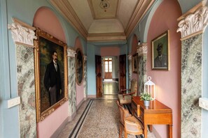 A hallway with classical architecture, including marble walls and ornate moldings. - Palazzo Rosati 1701 – An 18th-Century Palace with a Stunning View over Lake Como (Bonzanigo)