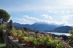 Un paisaje montañoso con un lago, casas y una construcción de piedra.
