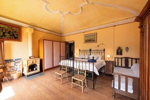 Ein traditionell eingerichtetes Schlafzimmer mit Himmelbett, Kamin und einem Bild an der Wand.