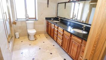 A bathroom with a toilet, a sink, and a mirror.