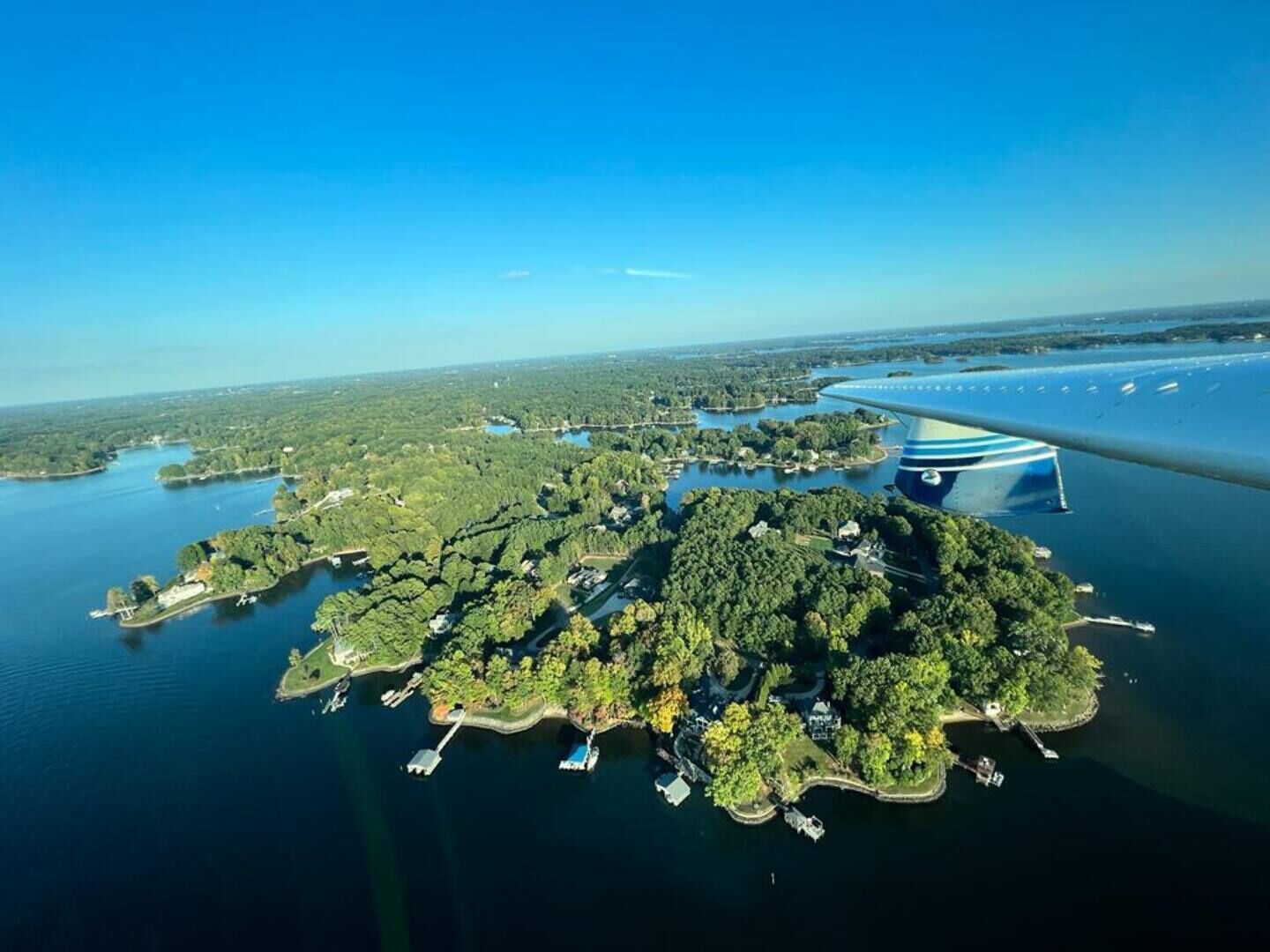 Une vue aérienne d’une grande île couverte d’une végétation luxuriante, avec plusieurs quais et un pont imposant.