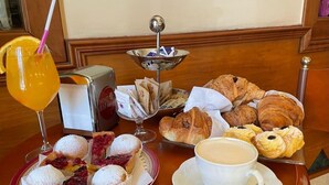 Una mesa de desayuno con pasteles, una bebida y una taza de café.