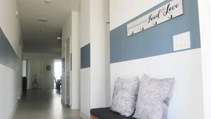 A hallway with a bench, a wall sign that reads "Food & Love," and a door at the end. - Champions Family Home - Near Disney (Davenport)