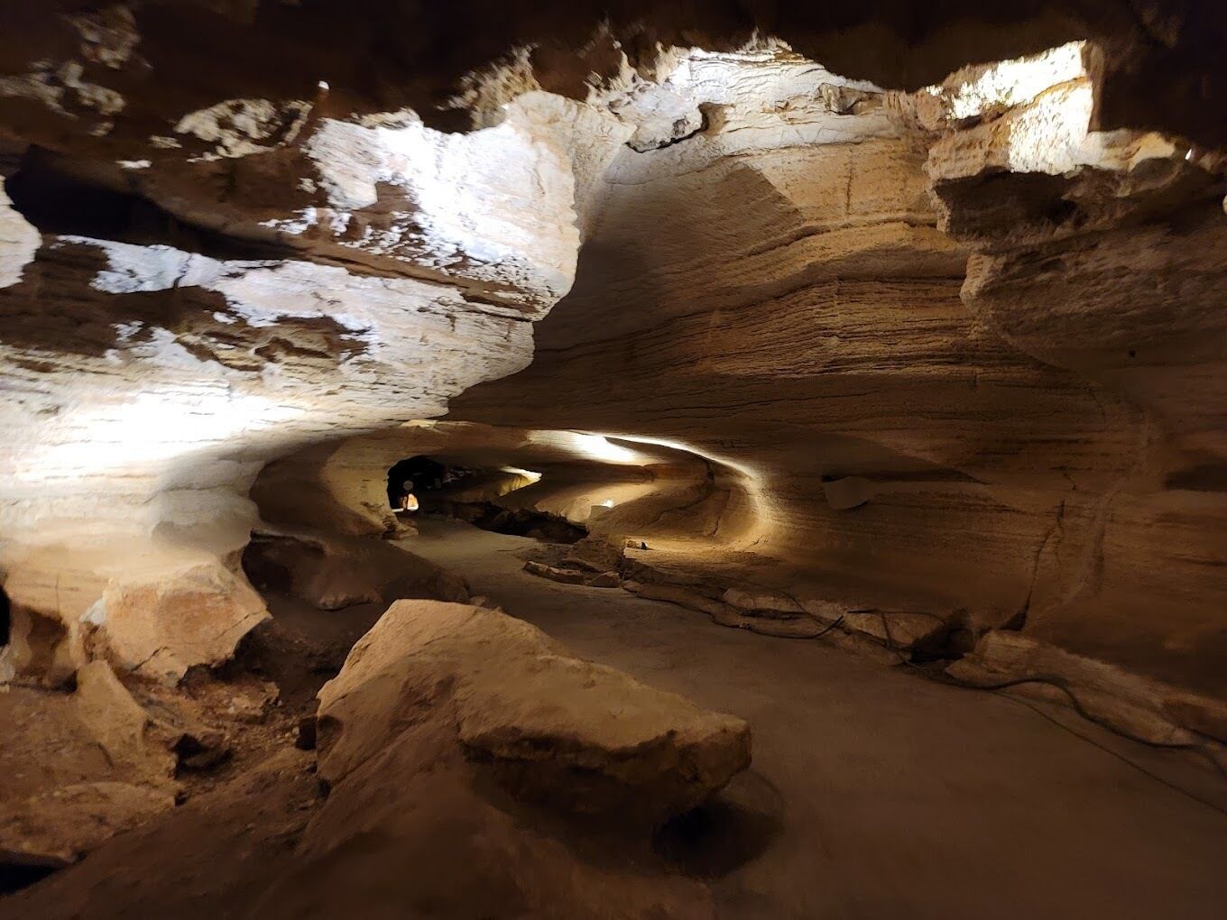 A cave with natural rock formations and a small opening.