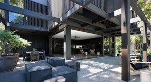 An outdoor patio area with seating, a dining table, and a view of the interior.