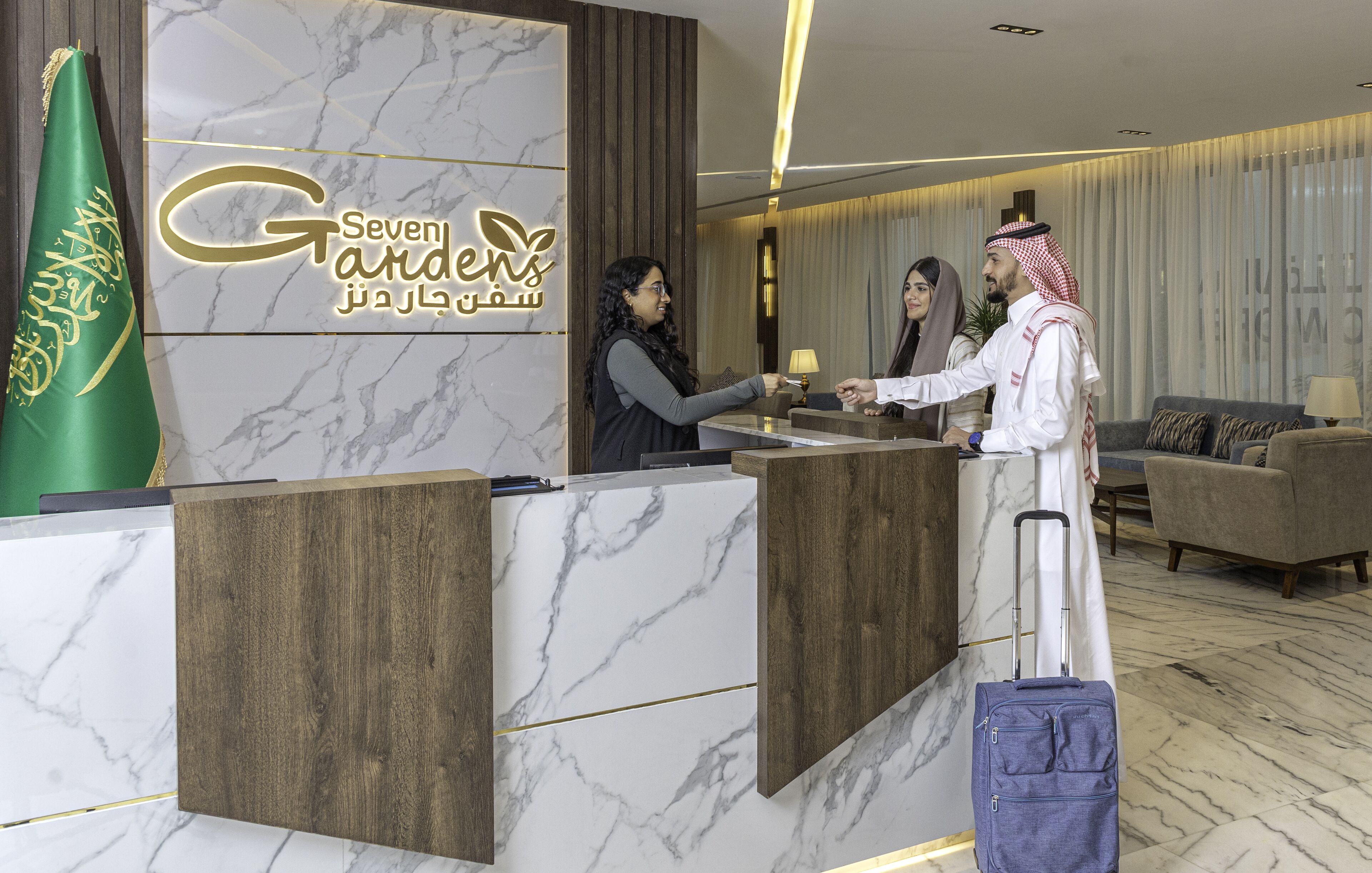 A reception desk with a marble design, a flag, and a sign reading "Seven Gardens."