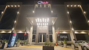 A hotel entrance with a modern facade, illuminated signage, and a welcoming entrance. - Seven Gardens Hotel (Riyadh)