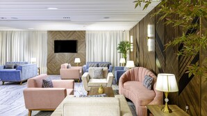 A modern living room with a flat-screen TV, plush sofas, and a coffee table. - Seven Gardens Hotel (Riyadh)