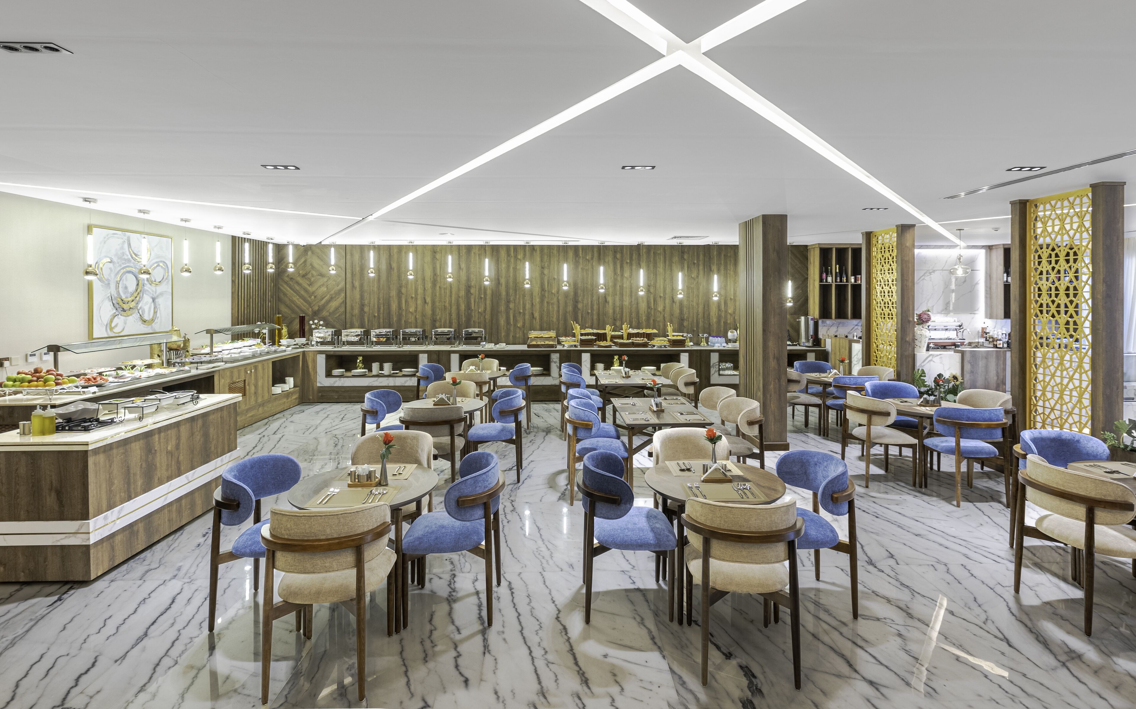 A modern hotel dining area with marble floors, blue and beige chairs, and a buffet counter.