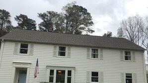 A two-story white building with a front entrance, a small porch, and a flag. - Renovated historic home! (Chapel Hill)