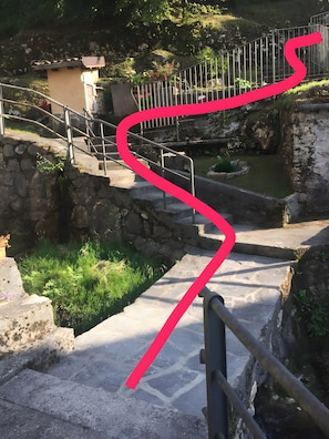 Eine Steintreppe führt zu einem kleinen Gebäude mit einem Metallgeländer.