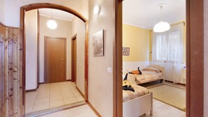 Una habitación de hotel con cama, mesita de noche, lámpara y ventana con cortinas.