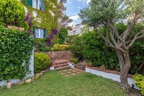 Un jardin agrémenté d’un escalier en pierre, d’une végétation luxuriante et d’un arbre.
