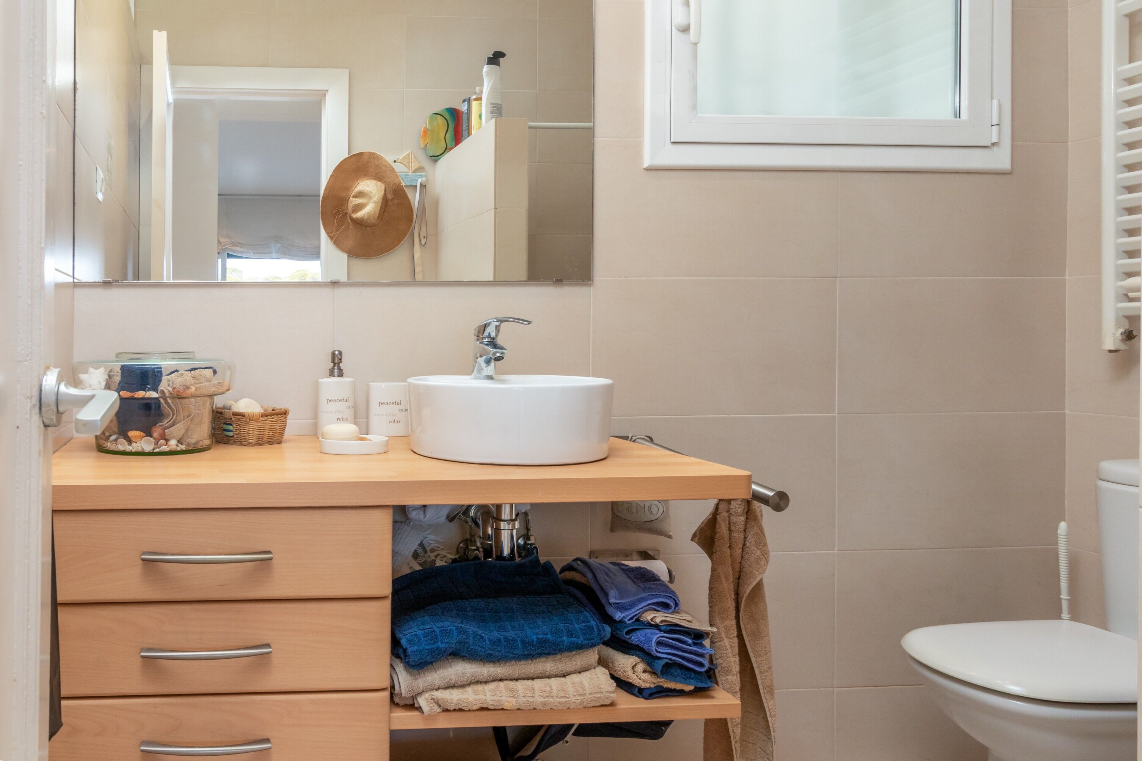 Een badkamer met een wastafel, spiegel en handdoekhouder.