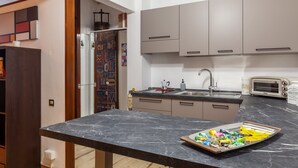 Een keuken met een marmeren aanrecht, een broodrooster en een spoelbak.