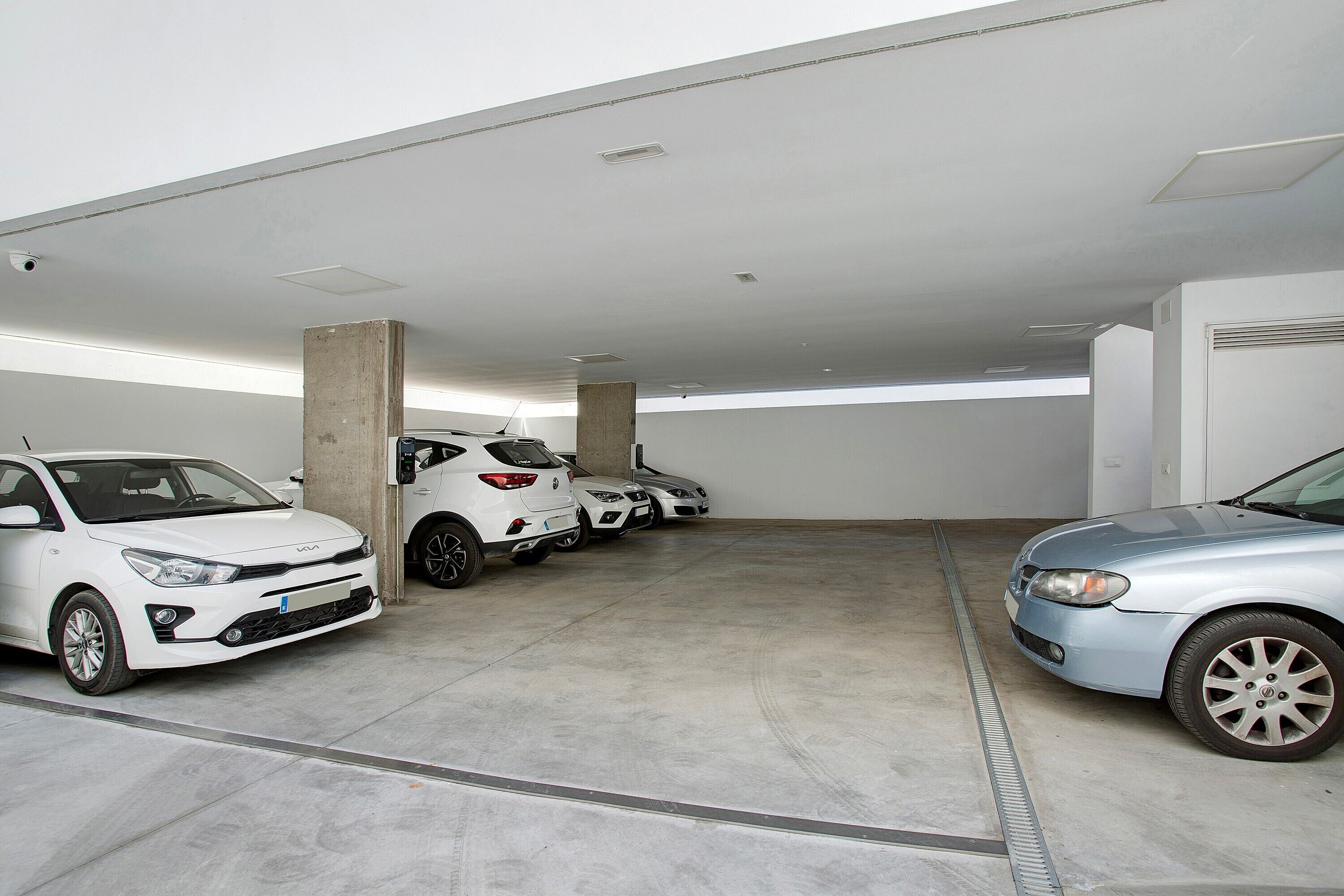 A parking garage with multiple cars parked in designated spaces.