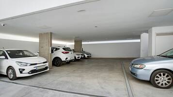 A parking garage with multiple cars parked in designated spaces.