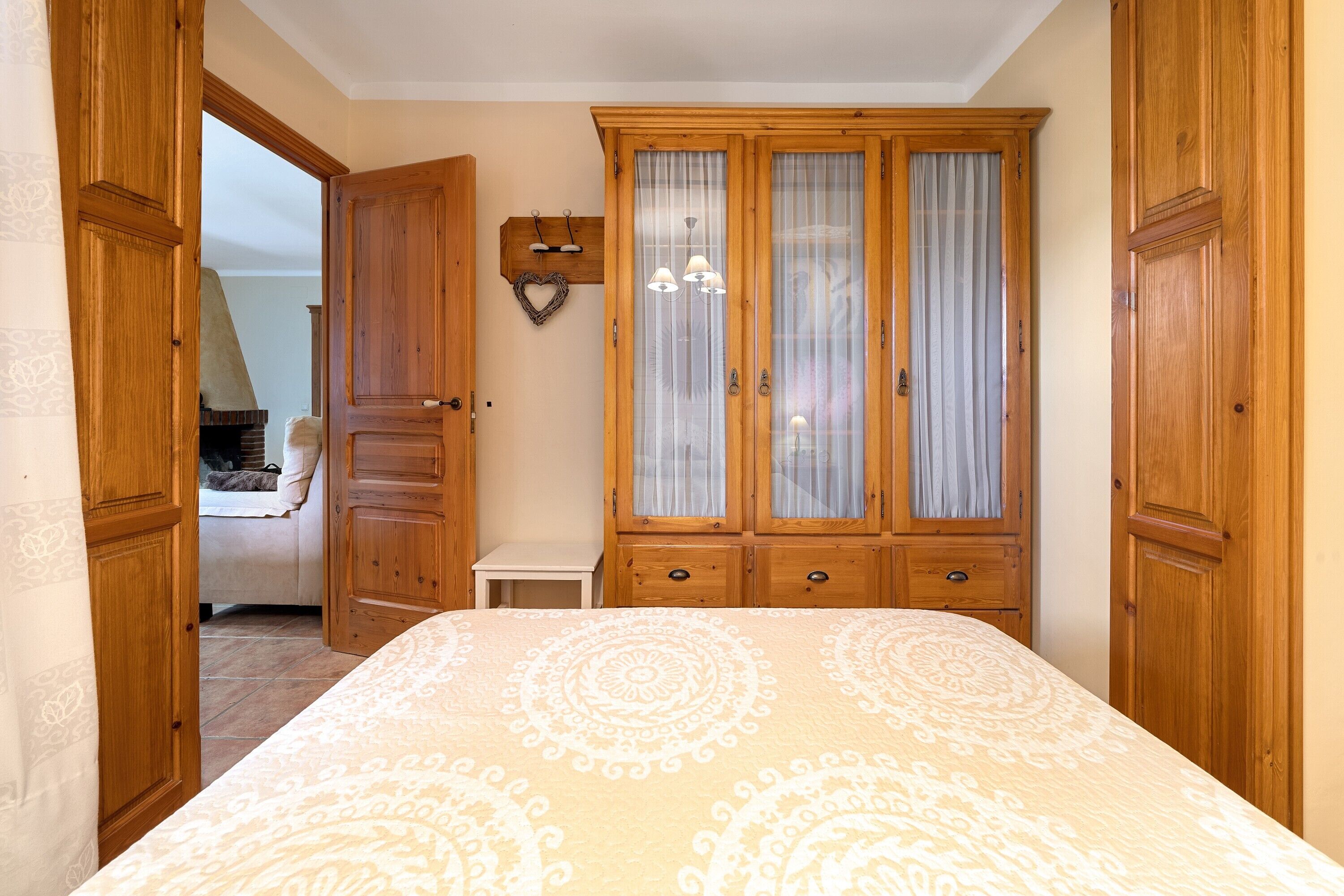 Ein Schlafzimmer mit einem Bett, einem Holzschrank und einem kleinen Nachttisch.