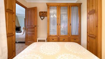 Ein Schlafzimmer mit einem Bett, einem Holzschrank und einem kleinen Nachttisch.