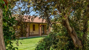 Une maison avec un toit en tuiles, une façade en briques et une pelouse bien entretenue.