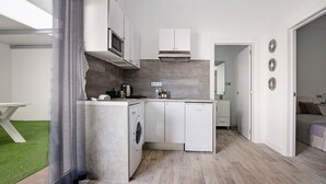 Une cuisine moderne équipée d’un lave-linge, d’un four à micro-ondes et de placards.