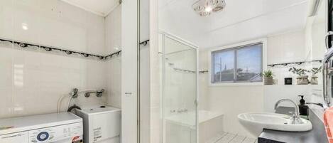 Bathtub, hair dryer, towels, toilet paper